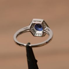 It is a lab sapphire ring. The main stone is 7mm*7mm round cut, weight about 1.63 carats.The basic metal is sterling silver and plated with rhodium.To change the metal to a solid gold (white/rose) or platinum is also available, please ask for a quotation if you want.You can also go to my shop Home for more elegant rings: https://www.etsy.com/shop/godjewelry?ref=hdr_shop_menuSapphire is the birthstone of September. More sapphire rings:https://www.etsy.com/shop/godjewelry?ref=listing-shop2-all-ite Octagon Ring, Vintage Anniversary Rings, September Birthstone Ring, Elegant Rings, Halo Wedding Ring, September Birthstone Rings, Blue Gemstone Rings, Sterling Silver Wedding Rings, Sapphire Rings