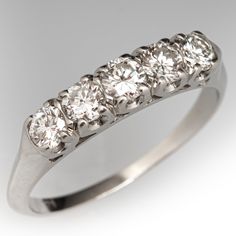 a five stone diamond ring is shown in white gold and has four diamonds on each side