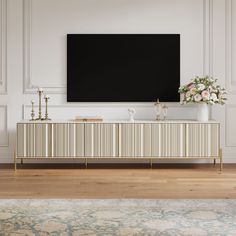 a large flat screen tv mounted to the side of a white and gold entertainment center