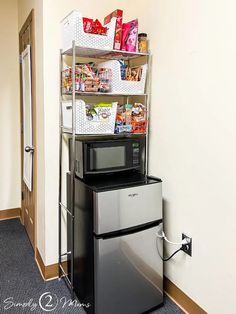 a microwave oven sitting on top of a refrigerator next to a shelf filled with food