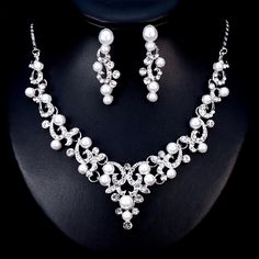 A classy bridal necklace and earrings set, perfect for the romantic bride! Adorned with iridescent pearls and clear crystals that capture the light from every angle sparkling beautifully, the pieces are rhodium plated for a flawless finish which enhances the intricate detailing and conveys a modern take on old elegance. Necklace: 16" long (approx. 41cm) with a 2.5" extension chain (approx. 6.5cm) which allows the length to be adjusted to 18.5" (approx. 47.5cm). If you would like it longer, pleas Formal Silver Pearl Jewelry Sets, Silver Pearl Embellished Jewelry Sets For Wedding, Elegant Crystal Jewelry Sets With Pearl Drop, Elegant White Crystal Jewelry Sets, Elegant Silver Pearl Jewelry Sets, Silver Pearl Wedding Jewelry Sets, Silver Jewelry Sets With Pearl Drop For Formal Occasions, Silver Pearl Jewelry With Rhinestones, Silver Bridal Necklace With Pearl Drop And Cubic Zirconia