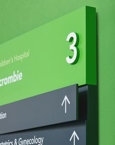 a green hospital sign with three arrows pointing in different directions and the number 3 on it