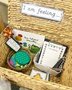 a wicker basket filled with lots of books and writing materials to teach children about feelings