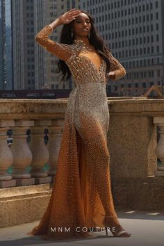 a woman in an orange and gold dress posing for the camera