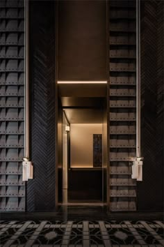 an open elevator with black and white tiles on the floor, leading to another room