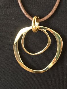 "The mattie gold tone metal two circle eyeglass necklace. An easy, pretty way to keep your eyewear close at hand and safe. Looks great as just a necklace also:) The hypoallergenic cotton cord is about 27\" long with a gold tone lobster clasp. The gold tone metal component is about 2 1/4\" in length and 1 3/4\" wide. If you would like another length cord, just specify the length preferred at checkout and I would love to make it for you! Thanks, Benita" Elegant Metal Necklace With Adjustable Cord, Everyday Metal Jewelry With Adjustable Cord, Elegant Metal Jewelry With Adjustable Cord, Elegant Gold Necklace With Adjustable Cord, Adjustable Cord Brass Gold Jewelry, Adjustable Gold Brass Jewelry With Cord, Gold Brass Jewelry With Adjustable Cord, Nickel-free Gold Jewelry, Gold Metal Necklace For Fashion Accessory