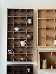 three wooden shelves with cups and vases on them