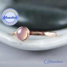 This Copper Rose Quartz Ring features a 6 mm cabochon that has been securely set in a highly polished fine copper bezel. The band is made of a sturdy round Copper wire that has been given a hammer texture, then carefully finished for comfortable wear. Our setting process involves carefully tightening the bezel around the stone, creating a water-tight seal with no stone movement. These beautiful rings make unique promise rings, lovely stacking rings, great birthstone rings, or just a wonderful lo Stackable Rose Gold Moonstone Ring, Stackable Round Moonstone Ring In Rose Gold, Handmade Rose Gold Moonstone Ring For Anniversary, Rose Gold Gemstone Stackable Rings, Rose Gold Stackable Rings With Bezel Setting For Gift, Rose Gold Moonstone Ring With Birthstone, Rose Gold Moonstone Birthstone Ring, Pink Quartz Ring, Pink Gemstone Ring