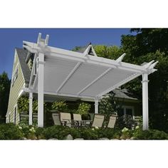 a white pergolated covered patio with chairs and table in the foreground on a sunny day