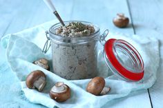 a jar filled with food sitting on top of a blue cloth next to some mushrooms