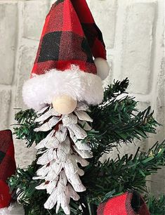 a red and black plaid christmas tree with a santa hat on it's head