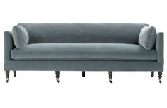 a gray couch with two pillows on it's back and legs, against a white background