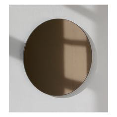 a round mirror hanging on the wall