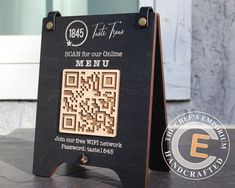 a wooden sign with a qr code on it sitting on top of a table