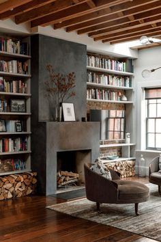 a living room filled with furniture and bookshelves next to a fire place in front of a fireplace