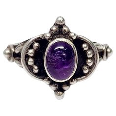 Sterling silver amethyst cabochon ring. Size 7 1/2 Oval bezel set amethyst cabochon in a bright purple color is surrounded by silver bead accents on a black oxidized background. Measures approx 5/8" high at front, center stone measures approx 7.5mm x 5.5mm. Weighs approx 4.5g, 2.9dwt Marked 925 Very nice condition with light tarnish and slight surface scratching. Will come packaged in a gift box or pouch (when possible) and will be shipped US Priority Mail with insurance. CL021324/17KCS Luxury Oval Cabochon Amethyst Ring, Luxury Purple Oval Cabochon Rings, Purple Amethyst Oval Cabochon Ring, Classic Amethyst Oval Cabochon Ring, Classic Purple Cabochon Rings, Hallmarked Oval Cabochon Amethyst Ring, Classic Cabochon Amethyst Ring, Classic Amethyst Cabochon Ring, Collectible Oval Cabochon Amethyst Ring