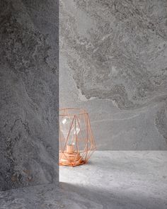 an orange vase sitting on top of a white counter next to a gray wall and floor