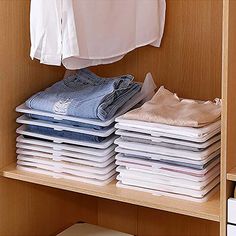 a wooden shelf filled with lots of folded clothes