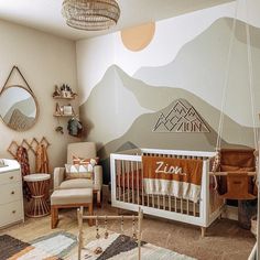 a baby's room with mountains painted on the wall