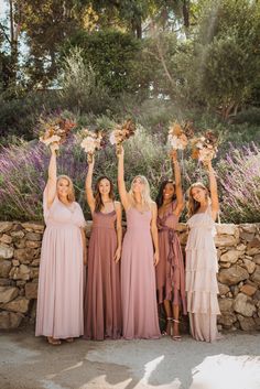 the bridesmaids are holding their bouquets in the air