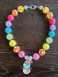 "Rainbow Snowman Chunky Bubblegum Rainbow Bead Necklace & Bracelet This Rainbow Snowman themed necklace will bring a smile to your little one's face! Great accessory to put with any color of the rainbow. This will make a lovely party favor, holiday party accessory or gift for birthdays or holidays. Made with primarily 20mm bubblegum beads in shades of pink, orange, yellow, green, blue and purple. The necklace measures approximately 11\" when toggled around neck including the unicorn pendant. Holiday Party Accessories, Disney Bracelet, Chunky Bead Necklaces, Unicorn Pendant, Bracelet Christmas, Pink Orange Yellow, Bubblegum Beads, Christmas Bracelet, Rainbow Beads