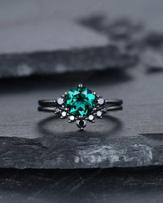 an emerald colored ring on top of a rock