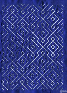 a blue background with white stitching on the bottom and an intricate design in the middle