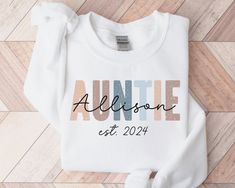 * HOLIDAY ORDER DEADLINE: DEC 9 * (Orders placed after this date may not arrive by Dec 24th.) Personalized Auntie Sweatshirt, Promoted to Aunt Please Note the Following: - A mockup can be sent if requested.  Please add request in the personalization area.  - I can offer custom requests. Please message me before purchasing to inquire. This adult sweatshirt is super soft; size up for a slouchy/oversized look. ITEM OVERVIEW * Gildan 18000 * Unisex crewneck sweatshirt * 50% Cotton, 50% Polyester * R White Sweatshirt With Name Print For Birthday, White Sweatshirt For Mother's Day, White Letter Print Sweatshirt For Birthday, Auntie Things, Birthday Gift For Aunt, Aunt Sweater, Auntie Sweatshirt, Promoted To Aunt, Aunt To Be