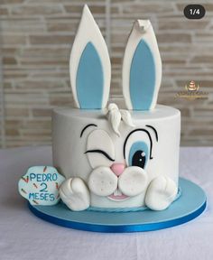 a white cake with blue frosting and bunny ears