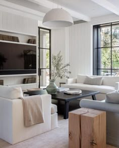 a living room filled with furniture and a flat screen tv mounted on the wall above it