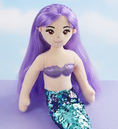 a stuffed mermaid doll with purple hair and blue sequins