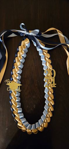 a close up of a necklace on a table with a ribbon tied around the neck