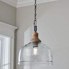 a clear glass light hanging from a ceiling