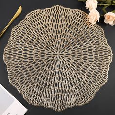 a white plate sitting on top of a table next to flowers and a gold fork