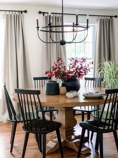 a dining room table with four chairs and a potted plant on top of it