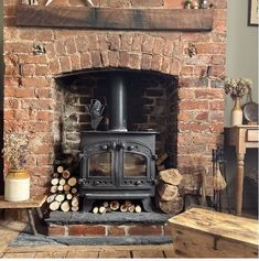 an old brick fireplace with logs stacked on the floor and a star above it, in a rustic living room