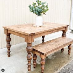 a wooden table with two benches next to it and a potted plant on top