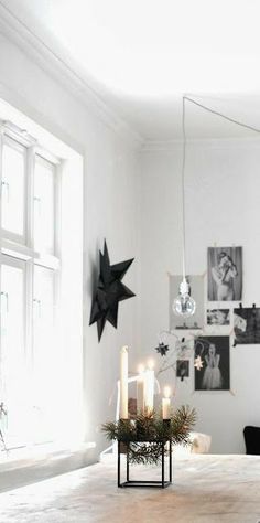 a dining room table with candles and pictures on the wall