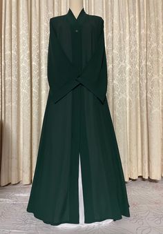 Soft lightweight dark green georgette long abaya cape with v-shaped neck, may also be worn as an open abaya. Front open single buttoned cape/stole with nice flare for a flowy and stylish look and ease of walking. A nice touch to your simple abaya or suit look.  Fabric and style suitable for all occasions and weather conditions.  Abaya cape may be worn with any color abaya or salwar or dress suit of your choice.  Available in size 52. This item comes as cape ONLY, it does not come with under abaya as shown in images.  (You may purchase linen abayas separately of your color choice from the shop to pair with this cape.) Dark Green Abaya, Coat Style Abaya, Abaya Cape, Color Abaya, White Hijab, Simple Abaya, Mode Abayas, Open Abaya, Peacock Color