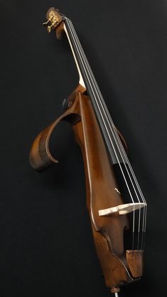 an old violin is laying on a black surface with the strings still attached to it