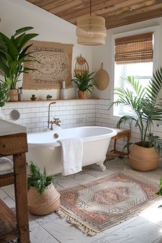 a white bath tub sitting in a bathroom next to a rug and potted plants