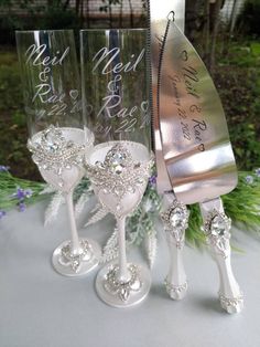 three wine glasses are sitting next to each other on a table with flowers in the background