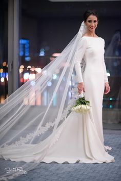 a woman in a white wedding gown and veil