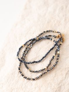 Add a beautiful and versatile piece to your collection with this Pyrite Wrap Bracelet & Necklace. Faceted Pyrite beads are paired with dark navy iridescent and gold beads. Known for good luck and abundance, Pyrite's radiant energy fosters confidence, and dynamism, encourages action, and aids in overcoming fears. Wear as a necklace or wrap 2-3 times for wear as a bracelet.Size: 18"-20" adjustable length. Cast of Stones’ bracelets and necklaces are inspired by ancient rituals and designed to promote love, positivity, and self-care. These beaded pieces help wearers set intentions and reflect on their personal purpose. Ancient Rituals, Linen Candle, Set Intentions, Radiant Energy, Ski Girl, 5 Gifts, For Good Luck, Bracelets And Necklaces, 50th Gifts