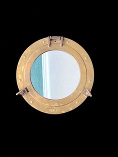 a porthole mirror on the side of a wall with an open door and rivets