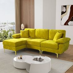 a living room with a large yellow couch and coffee table in front of a window