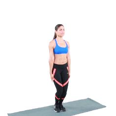 a woman standing on a yoga mat with her hands behind her back