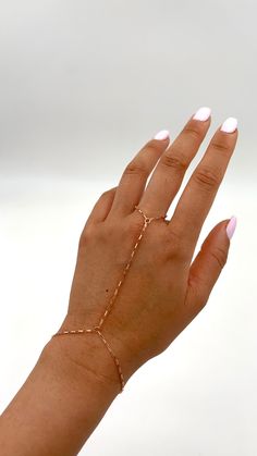 "Shiny and chic chain is beautifully crafted to accentuate your hand.  This chain is dainty yet sturdy. Materials used are 14k Gold Filled, 14k Rose Gold Filled, and Sterling Silver.  You may absolutely expose to water, and it will keep its color.   ::Color/ Materials Options:: Gold (14k Gold Filled) Rose Gold (14k Rose Gold Filed) Silver (Sterling Silver) ::Sizing:: Small: ring chain fits up to Size 10, top of hand length 2.75\", wrist fits 6\"-7\" Medium: ring chain fits up to Size 10,  top of hand length 3\", wrist fits 6\"-7\" Large: ring chain fits up to size 12,  top of hand length 3.25\", wrist fits 6.5\"-7.5\" Custom: Please message us.  We are happy to customize your hand chain.  Have your wrist size (inches), and Ring size ready.  Outside of USA, you can measure with cm around yo Rose Gold 14k Gold-filled Jewelry With Adjustable Chain, Rose Gold Chain Jewelry For Party, Rose Gold Link Jewelry With Delicate Chain, Rose Gold Link Jewelry, Rose Gold Link Chain Bracelet With Adjustable Chain, Delicate Link Chain Jewelry, Rose Gold Link Jewelry With Adjustable Chain, Fine Jewelry In 14k Gold Filled Rose Gold, Rose Gold Link Chain Bracelet