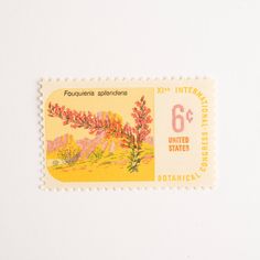 a postage stamp with an image of mountains and trees on the front, in yellow