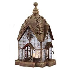 a small house made out of metal and glass with a clock on the front window